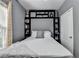 Comfortable bedroom featuring built in shelves and a large bed with a white comforter at 2220 Lily Valley Dr, Lawrenceville, GA 30045