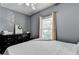 Sunlit bedroom showcasing a stylish dresser, complemented by a window with patterned curtains at 2220 Lily Valley Dr, Lawrenceville, GA 30045