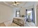 Comfortable bedroom featuring a ceiling fan, tray ceiling, and natural light from the two windows at 2220 Lily Valley Dr, Lawrenceville, GA 30045