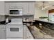 Bright kitchen with white appliances, granite countertops, and tiled backsplash with an open layout at 2220 Lily Valley Dr, Lawrenceville, GA 30045
