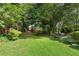 A beautiful backyard with large trees, shrubs, green grass, and lush greenery at 2249 Beecher Sw Rd, Atlanta, GA 30311