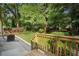 A charming backyard featuring a concrete patio, green grass, wood fence, and lush, mature trees at 2249 Beecher Sw Rd, Atlanta, GA 30311