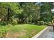 A spacious backyard with a large lawn and a variety of trees and shrubs at 2249 Beecher Sw Rd, Atlanta, GA 30311