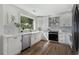 Well-lit kitchen with stainless steel appliances, white cabinets, and hardwood floors at 2249 Beecher Sw Rd, Atlanta, GA 30311