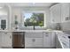 Bright and modern kitchen with white cabinets, stainless steel appliances and large window at 2249 Beecher Sw Rd, Atlanta, GA 30311