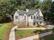 Rear view of home featuring painted brick, manicured yard and lush tree coverage at 2249 Beecher Sw Rd, Atlanta, GA 30311