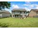 View of the rear exterior with large backyard including a grill and patio set, perfect for outdoor dining at 4275 Hunters Walk Way, Cumming, GA 30028