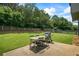 A lovely backyard featuring an outdoor grill, a picnic table, a wooden fence, and towering trees at 4275 Hunters Walk Way, Cumming, GA 30028