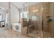 Bright bathroom with a tub and glass-enclosed shower and neutral tile at 4275 Hunters Walk Way, Cumming, GA 30028