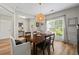 Light and airy dining room featuring wood floors, a central light fixture, and windows offering outdoor views at 4275 Hunters Walk Way, Cumming, GA 30028