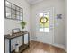 Welcoming foyer featuring a console table, wood floors, and a bright front door with a decorative wreath at 4275 Hunters Walk Way, Cumming, GA 30028
