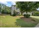 Charming home exterior featuring lush green lawn, mature trees, and manicured landscaping in the front yard at 4275 Hunters Walk Way, Cumming, GA 30028