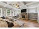 Comfortable living room with a fireplace, built-in shelving, neutral decor, and wood flooring at 4275 Hunters Walk Way, Cumming, GA 30028