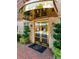 Elegant building entrance featuring gold trim, brick walkway, and well-maintained landscaping at 77 Peachtree Ne Pl # 211, Atlanta, GA 30309