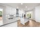 Open-concept kitchen with white cabinets, stainless steel appliances, center island and beautiful hardwood floors at 219 Phillips Ln, Alpharetta, GA 30009