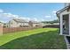 A large, well-maintained backyard with lush green grass and a wood privacy fence under a blue sky at 35 Henson Farm Dr, Loganville, GA 30052