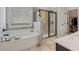 Modern bathroom with a soaking tub under a window and a glass-enclosed shower, offering a spa-like experience at 35 Henson Farm Dr, Loganville, GA 30052