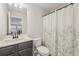 Bathroom featuring a vanity with dark gray cabinetry, a white toilet, and a patterned shower curtain at 35 Henson Farm Dr, Loganville, GA 30052