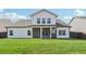 Backyard view of the home featuring a large lawn, privacy fence, and screened-in patio at 35 Henson Farm Dr, Loganville, GA 30052