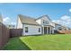 Exterior rear view showcasing a well-kept lawn, wood fence, and screened in porch at 35 Henson Farm Dr, Loganville, GA 30052