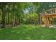 Backyard with wooden deck, surrounded by mature trees at 5195 Overbend Trl, Suwanee, GA 30024