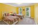 Charming bedroom with twin beds, colorful quilt bedding, and bright yellow walls at 5195 Overbend Trl, Suwanee, GA 30024