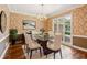Elegant dining room with chandelier, glass table, and views of the outside greenery at 5195 Overbend Trl, Suwanee, GA 30024