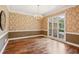 Dining room features classic wallpaper, hardwood floors and a chandelier for a formal setting at 5195 Overbend Trl, Suwanee, GA 30024