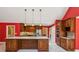 Modern kitchen with stainless steel appliances, large island with seating, and red accent wall at 5195 Overbend Trl, Suwanee, GA 30024