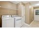 Functional laundry room with modern washer and dryer, storage shelving, and practical design at 5195 Overbend Trl, Suwanee, GA 30024