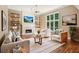 Cozy living room with a fireplace, comfortable seating, and a view of the beautifully landscaped backyard at 5195 Overbend Trl, Suwanee, GA 30024