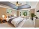 Cozy main bedroom with bay windows, ceiling fan, decorative art, and stylish furniture at 5195 Overbend Trl, Suwanee, GA 30024