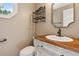 Charming powder room featuring a wooden countertop, classic vanity, and neutral wall color at 5195 Overbend Trl, Suwanee, GA 30024