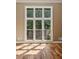 Sunlight streams into the room through the large window, illuminating the hardwood floors at 5195 Overbend Trl, Suwanee, GA 30024