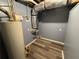 A utility area in the basement with a water heater and updated laminate flooring at 110 Stagecoach Trl, Stockbridge, GA 30281