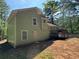 An exterior back view of a light green two-story home with a back deck at 110 Stagecoach Trl, Stockbridge, GA 30281