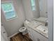 Bathroom featuring a modern vanity with granite countertop, sink, toilet, and window at 3120 Chattahoochee Rd, Cumming, GA 30041