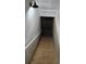 Wooden stairs leading to a basement with railing on one side and a vintage light fixture overhead at 3120 Chattahoochee Rd, Cumming, GA 30041
