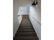 Carpeted stairs with white railings lead to the upper level of the home, featuring a modern light fixture at 3120 Chattahoochee Rd, Cumming, GA 30041