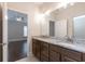 Bathroom featuring double sink vanity with granite countertop leading to bedroom and shower at 601 Cork St, Woodstock, GA 30188