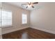 Bright bedroom featuring hardwood floors, plantation shutters, and a ceiling fan at 601 Cork St, Woodstock, GA 30188