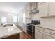 Kitchen with stainless steel stove and oven, hardwood floors, and bright white cabinets at 601 Cork St, Woodstock, GA 30188