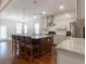 Bright kitchen with bar seating on a center island, stainless appliances, and hardwood floors at 601 Cork St, Woodstock, GA 30188