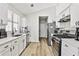 Bright kitchen featuring white cabinets, stainless steel appliances, and wood-look flooring at 3915 Basil Sw Way, Atlanta, GA 30331