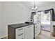 Open-concept kitchen with island, white cabinets, and sliding glass doors at 3915 Basil Sw Way, Atlanta, GA 30331