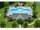 Aerial view of a community pool, lounge area, clubhouse, fire pit, and mature trees at 5780 Winding Lakes Dr, Cumming, GA 30028