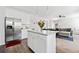 Open kitchen with stainless steel refrigerator, island, and view of the living room with comfortable seating at 5780 Winding Lakes Dr, Cumming, GA 30028