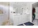 Bathroom featuring a double vanity, tiled shower, and access to walk in closet at 5780 Winding Lakes Dr, Cumming, GA 30028