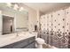 Well-lit bathroom features a shower with patterned curtain, vanity with a large mirror, and neutral wall color at 1800 Clairmont Lk # A310, Decatur, GA 30033