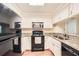 The kitchen features white cabinets and black appliances plus granite counters at 1800 Clairmont Lk # A310, Decatur, GA 30033
